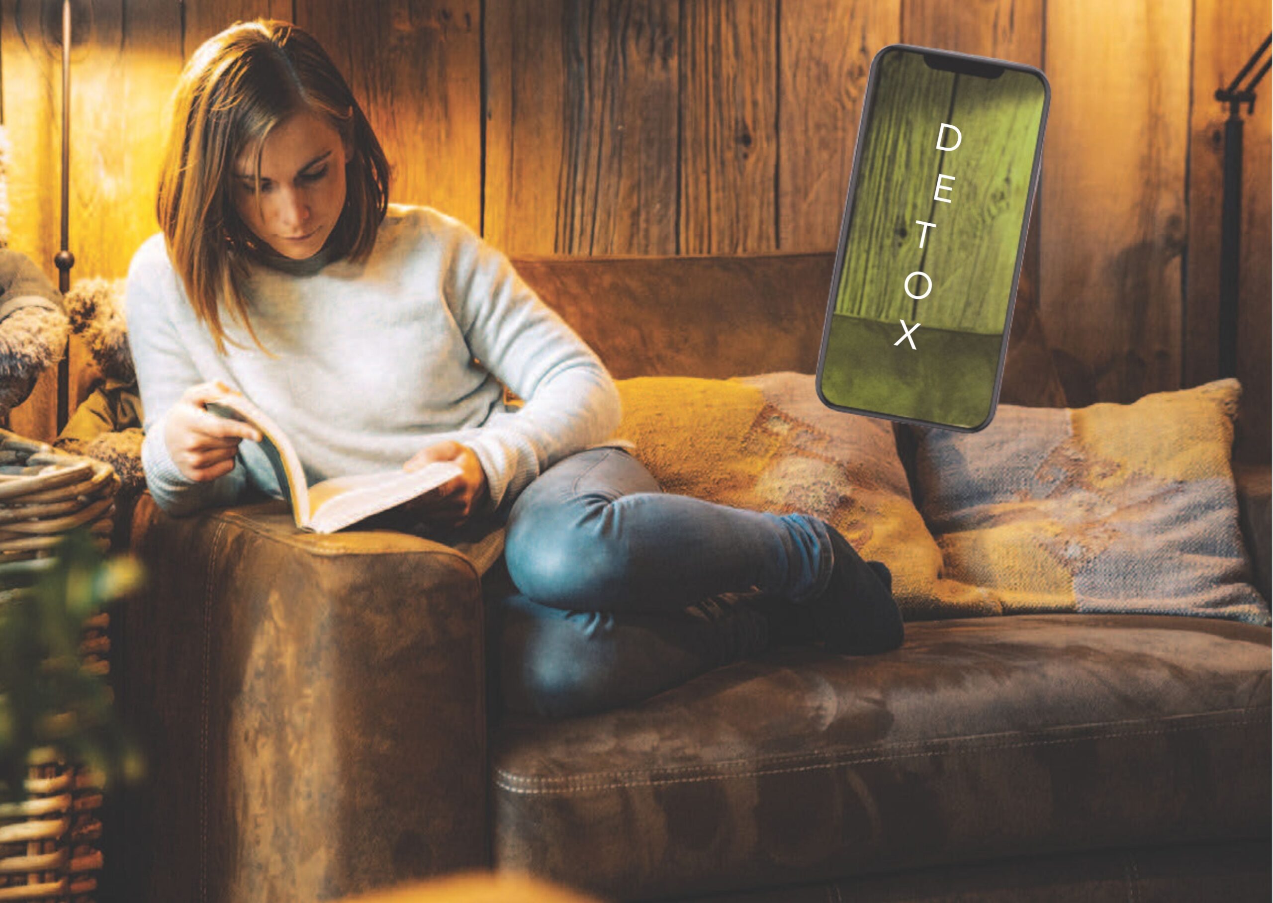Femme lisant un livre dans un fauteuil, téléphone en arrière-plan — détox digitale