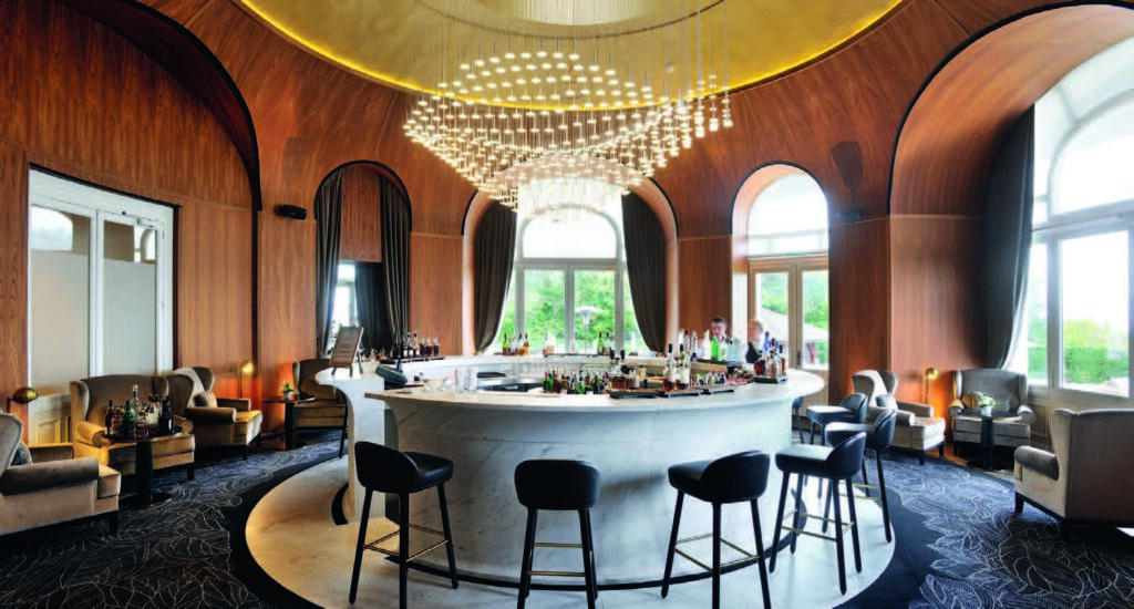 Bar élégant à Evian Resort : matières chaudes, architecture et convivialité.