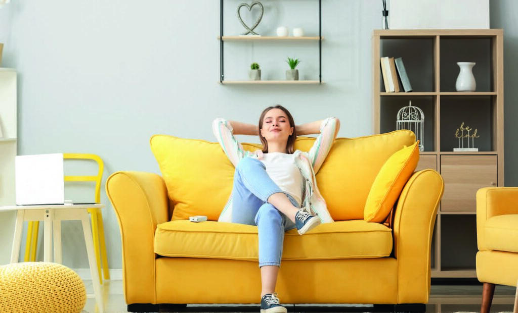 Intérieur lumineux avec canapé jaune, évoquant l’harmonie et le renouveau après un ménage de printemps.