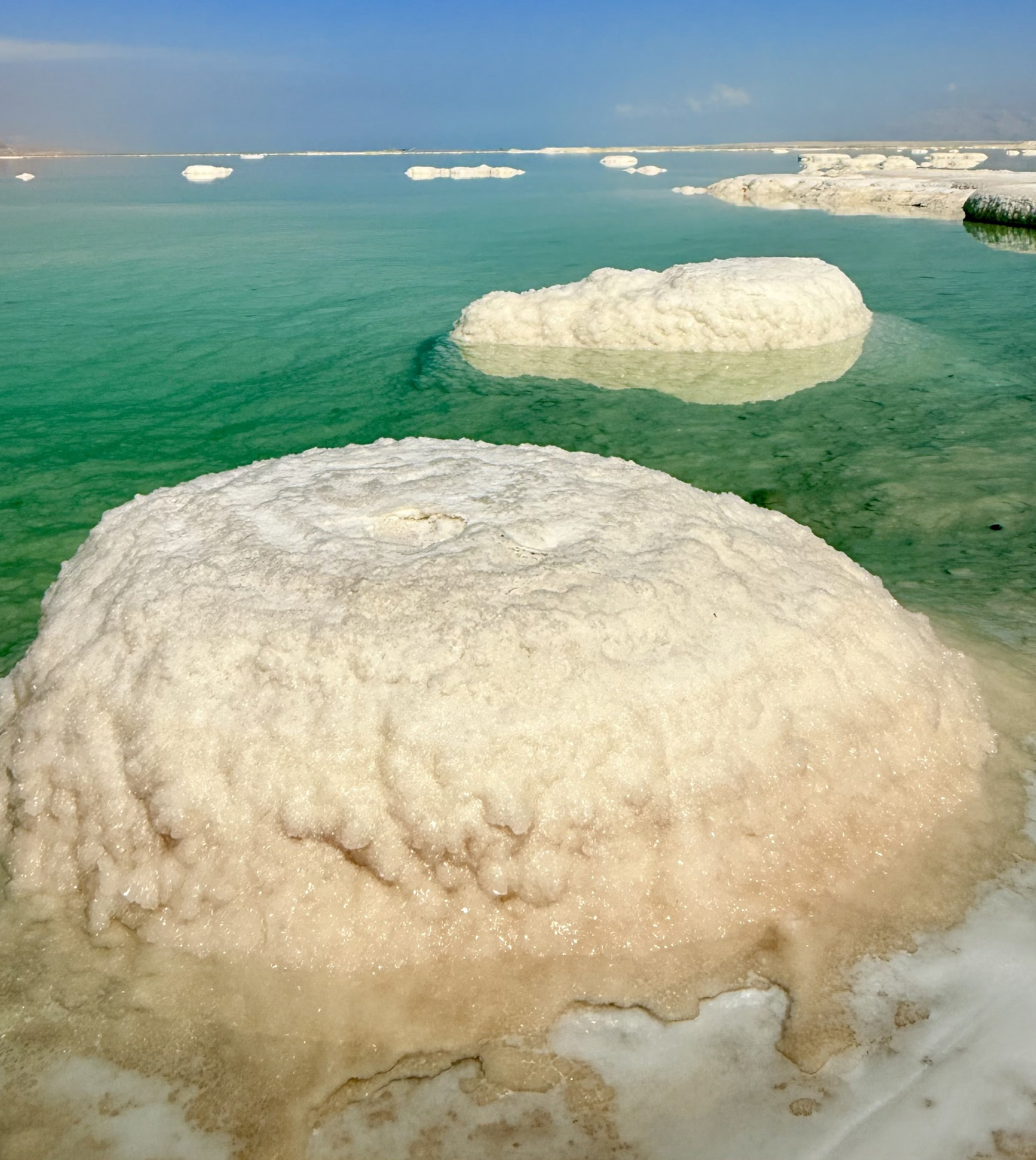 Formations blanches de sel émergeant des eaux turquoise de la Mer Morte.